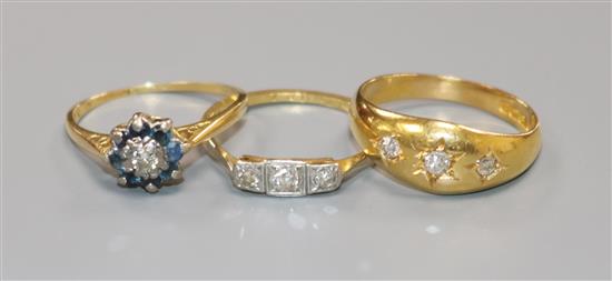 Three assorted 18ct gold and gem set rings including diamond.